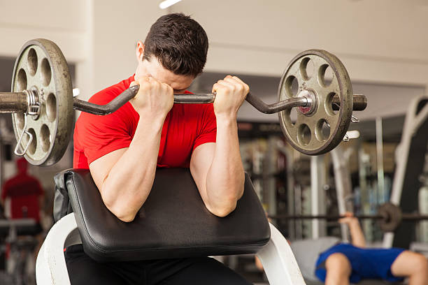 a men doing biceps preacher curl - biceps exercise