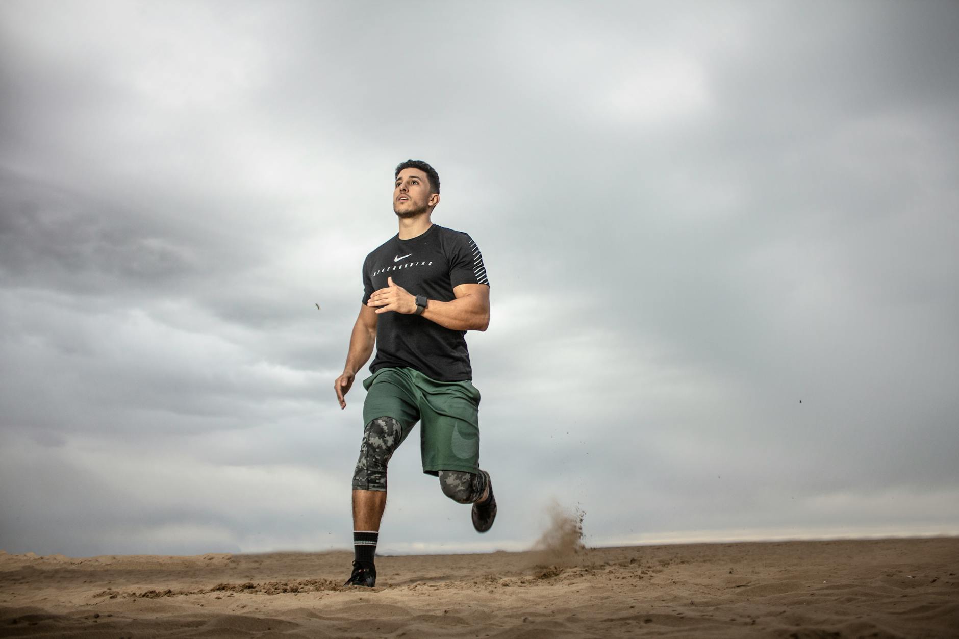 man running on sand field for fitness goals